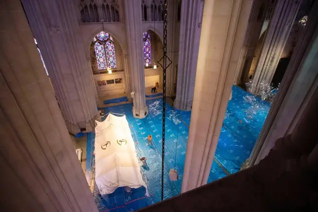 Volunteer erecting a tent inside the Cathedral of St. John the Divine in New York, the site of a now-cancelled field hospital
